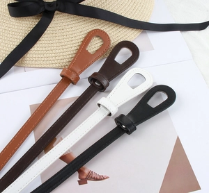 Detailed view of slim fashion belts in four colors with minimalist oval loop buckles