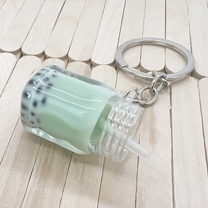 Close-up of mint green bubble tea keychain with realistic resin pearls and silver ring