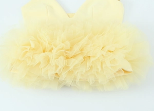 Detail van gelaagde gele mesh-stof met geplooide textuur op een mouwloze top voor dames