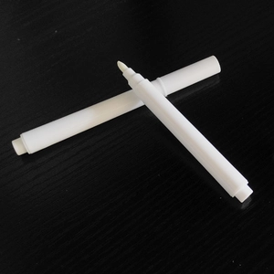 Set of two white liquid chalk markers with fiber tips on dark wood surface