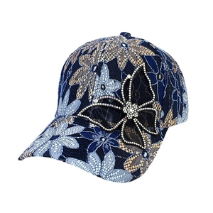 Blue floral lace baseball cap with rhinestone butterfly decoration on a white background