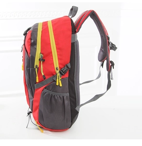 Side view of red and grey outdoor backpack with mesh pockets and yellow zipper pulls