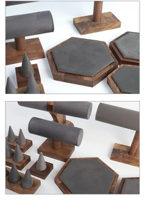 Macro view of walnut wood and grey velvet jewelry trays with ring cones and bracelet stands