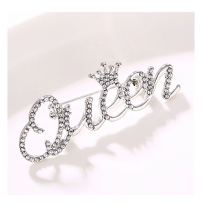 Macro detail of silver Queen letter brooch with crown accent and crystal pavé setting