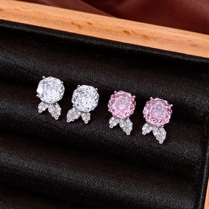 Macro detail of rose flower stud earrings with zircons on black velvet box