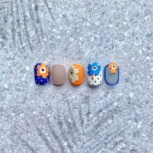 Detail of 3D embossed floral nail charms with vibrant blue and orange matte finish