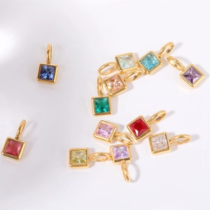 Macro view of square 18k gold plated titanium steel charms with colorful gemstones