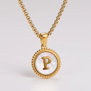 Detail of gold box chain and round shell pendant with embossed letter P engraving