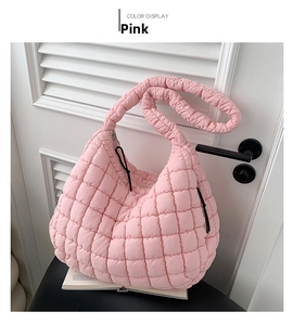 Detailed view of pink quilted cloud bag with padded nylon texture and wide strap