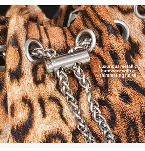 Detailed macro view of silver metallic eyelets and chain on a leopard print bucket bag