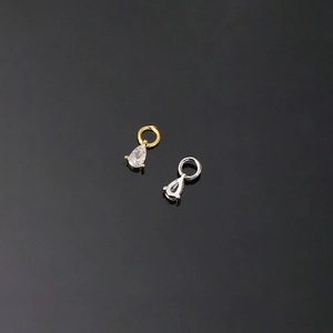 Macro detail of pear-cut cubic zirconia charms in gold and silver plating