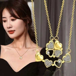 Close-up of gold clover necklace with heart-shaped petals and zircon stone inlay