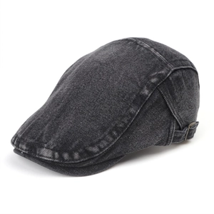 Detail of washed black denim beret featuring adjustable metal side buckle and vintage texture