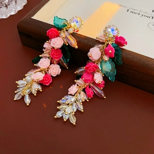 Détails de boucles d'oreilles vintage fleurs et glands en cristal sur fond bois brun