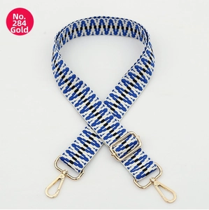 Close-up of ethnic style woven bag strap with geometric patterns and gold metal hardware