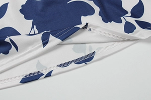Detail eines weißen Kleides mit marineblauem Blumendruck und präzisen Doppelnaht-Säumen