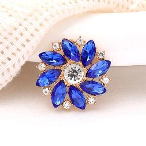 Macro shot of radial gold alloy brooch with deep blue marquise rhinestones and crystals