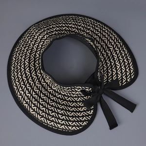 Detail of wide brim sun visor with geometric black and white woven pattern and ribbon
