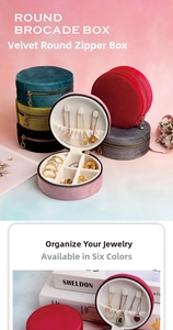 Detailed view of round velvet jewelry box showing ring slots and necklace hooks