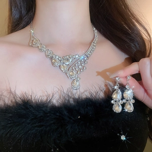 Close-up of sparkling silver crystal droplet necklace and earrings set on an elegant model