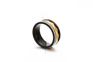 Detailed macro view of an 8mm stainless steel ring with black and gold wave inlay and zircons