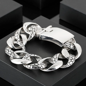 Detailed macro view of silver Cuban link bracelet with snake skin texture and polished finish