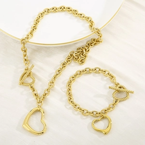 Detail shot of golden heart pendant necklace and bracelet set with toggle T-bar closure