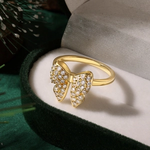 Close-up of a gold butterfly ring with pave zircons in a velvet gift box with pine decor