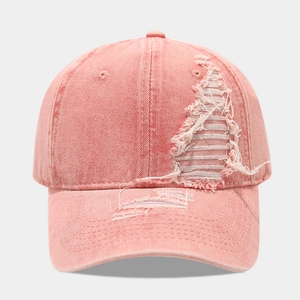 Close-up of pink washed denim baseball cap with distressed details and ripped textures