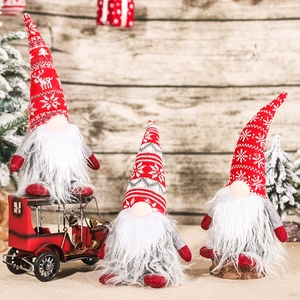Trois gnomes de Noël de tailles variées sur un modèle de voiture rouge décoration