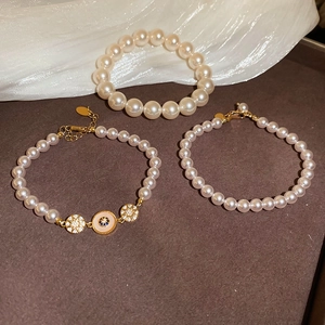 Détail de bracelets plaqués or 18 carats avec perles lustrées et accents de zircon