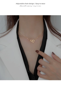 Detail of interlocking double heart pendant with adjustable extension chain on gold necklace