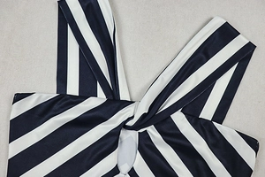 Detail of the black and white striped dress showing the twist-front knot and ribbed fabric