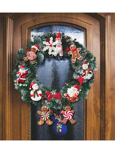 Christmas wreath with Santa and gingerbread ornaments hanging on a dark wooden door