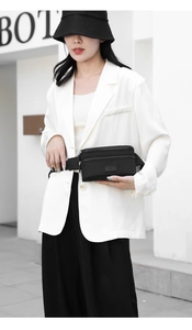Detail of waterproof black oxford fabric waist bag showing multi-layer zippers and strap