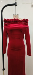 Detail of red velvet off-shoulder dress with 3D rose decoration on the neckline
