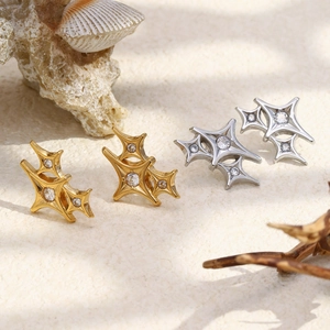 Macro detail of triple star earrings in gold and silver plating with cubic zirconia