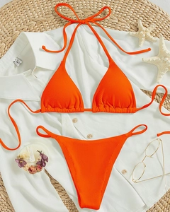 Close-up of ribbed bright orange bikini with halter neck tie and starfish decorations