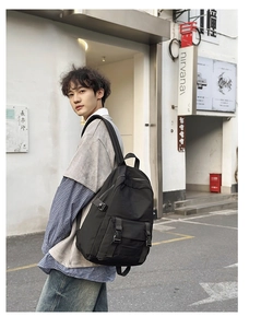 Hombre lleva una mochila de negocios grande negra e impermeable de tela Oxford en la calle
