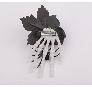 Detail view of Halloween hair clip with bone hand, black maple leaf and spider on the back