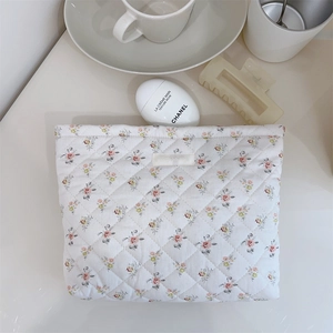 Detail of floral quilted cotton makeup bag with brand label and shockproof texture