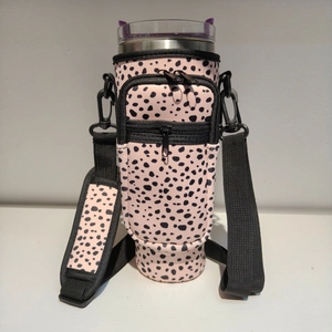 Close-up of leopard print 40oz tumbler sleeve with dual pockets and adjustable strap