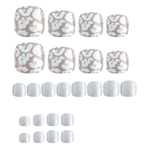 Press on toe nails featuring white glossy finish and brown cow print patterns
