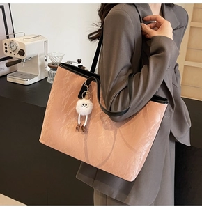 Borsa tote rosa con trama rocciosa, manici in pelle nera e ciondolo di peluche