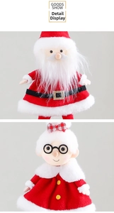 Detail of plush Santa and Mrs. Claus ornaments featuring festive red fabric and white fur