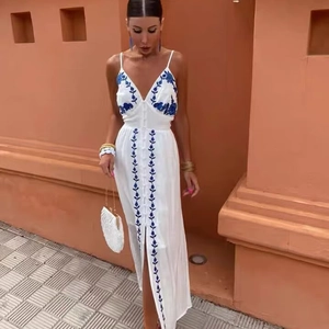 White boho maxi dress with blue floral embroidery, deep V-neck and front buttons