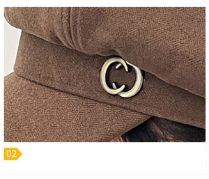 Detail shot of the dark brown wool octagonal hat with vintage interlocking metal buckle