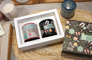 Detail view of double-lid tin canisters with floral pattern in a white window gift box