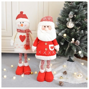 Dettaglio di peluche di Babbo Natale e pupazzo di neve a maglia vicino all'albero