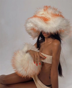 Detail of white faux fur oversized bucket hat and matching cuffs with orange stripes